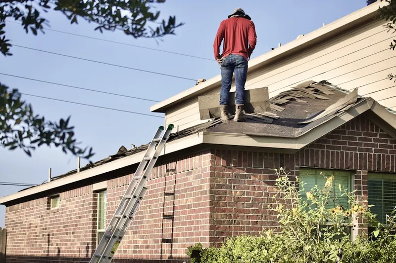 Professional roofer working on a residential roof in Foley